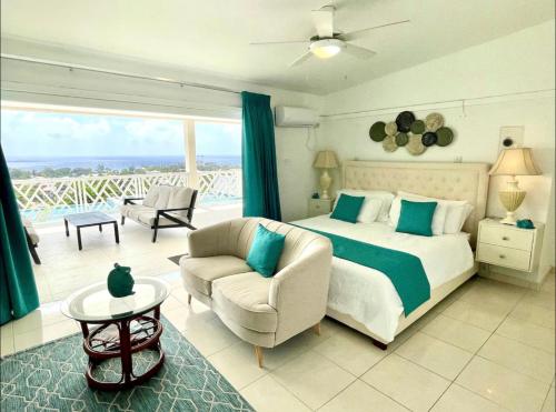 布里奇敦的住宿－Luxury 4 Bed Villa in Barbados with amazing views，一间卧室配有一张床、一张沙发和一把椅子
