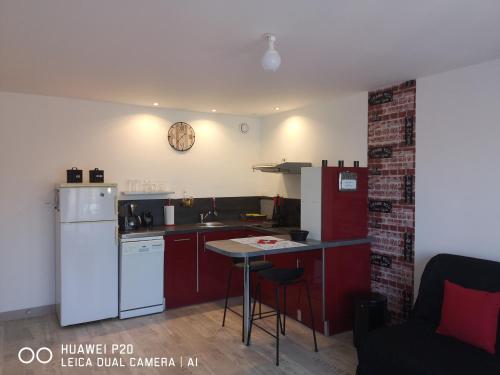 cocina con armarios rojos y nevera blanca en Loc126 en Montreuil-Bellay