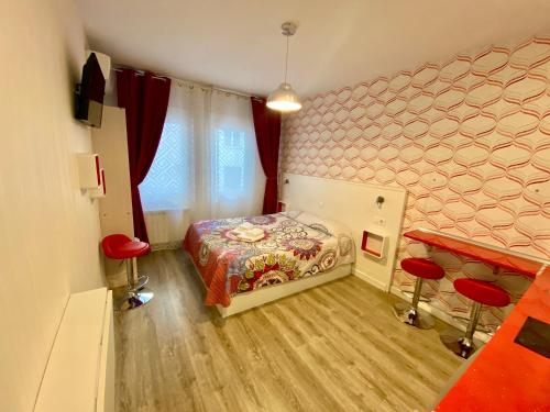 マドリードにあるMuchoMadrid Apartmentsの小さなベッドルーム(ベッド1台、赤い椅子2脚付)