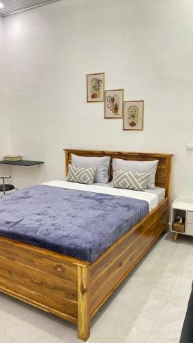1 dormitorio con cama de madera y colchón morado en Juliana HomeStay, 