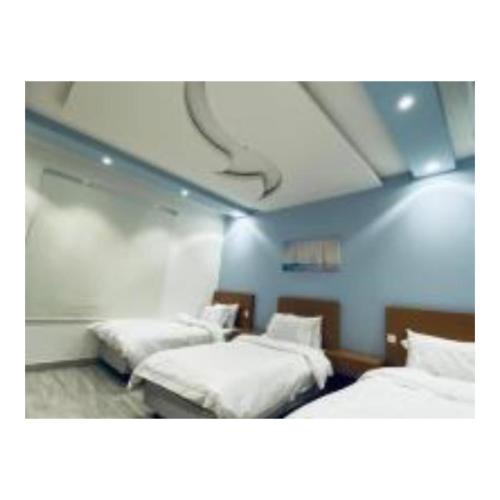 um quarto com duas camas e um tecto em Diamond suites em Al Madinah