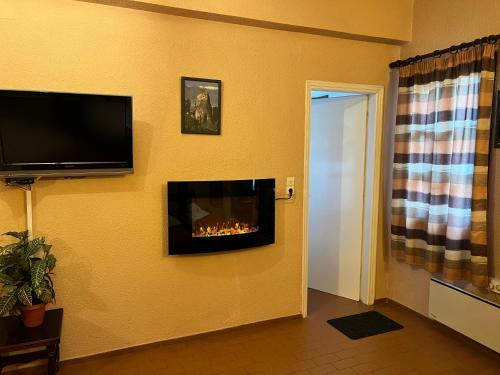 a living room with a fireplace and a flat screen tv at Rigas Hotel Arachova in Arachova
