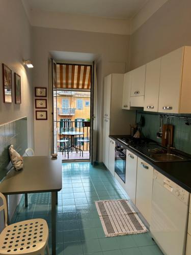 a kitchen with white cabinets and a green tile floor at Vatican Attic in Rome