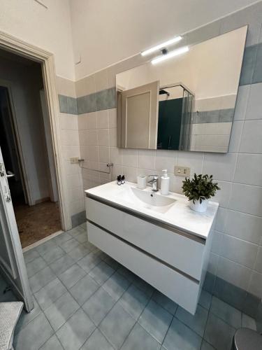 een badkamer met een witte wastafel en een spiegel bij Vatican Attic in Rome