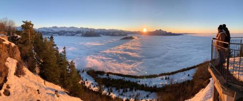 a woman standing on a ledge looking out over a lake at Rigiana auf der Königin der Berge in Rigi Kaltbad