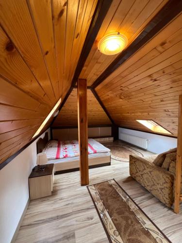 Cette chambre mansardée comprend un lit et un canapé. dans l'établissement Panorama Guest House, à Smolyan