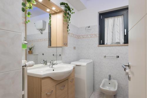 a white bathroom with a sink and a toilet at La Casa dei Nonni in Isola del Gran Sasso dʼItalia