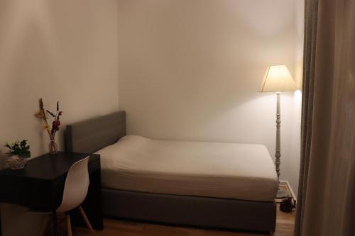 a bedroom with a bed and a desk and a lamp at Cosy room near Berlin and close to Tesla Factory in Brandenburg 