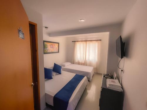 a hotel room with two beds and a television at Sweet Caribbean Hotel in San Andrés