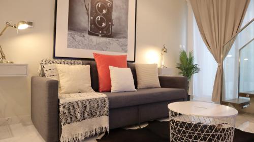 un soggiorno con divano e cuscini colorati di Desert Rose Apartment- Masdar City a Al Qurayyah