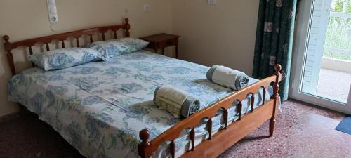een slaapkamer met een bed met 2 kussens erop bij Chez Effie in Kamena Vourla