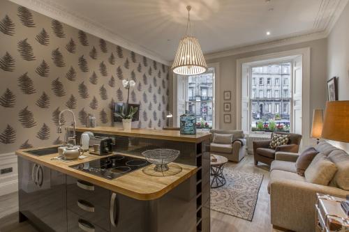 a kitchen with a stove and a living room at Haymarket Apartments in Edinburgh