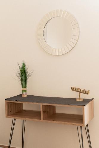 a mirror and a wooden shelf with a plant on a wall at Starfish Complex in Porto Rafti