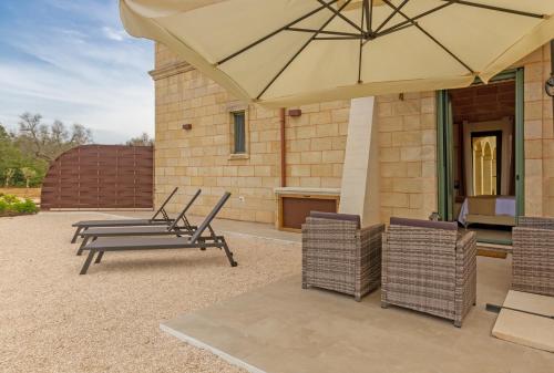 a patio with a table and chairs and an umbrella at TENUTA DOROLIVO in Otranto