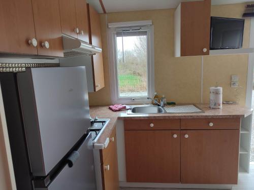 eine Küche mit einem weißen Kühlschrank und einer Spüle in der Unterkunft Mobilhome 1 
