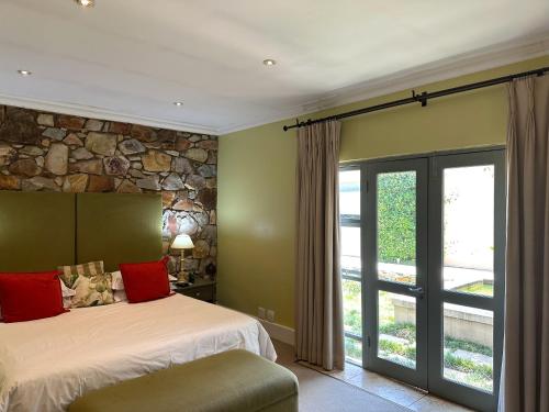 a bedroom with a bed and a stone wall at The Parkwood in Johannesburg