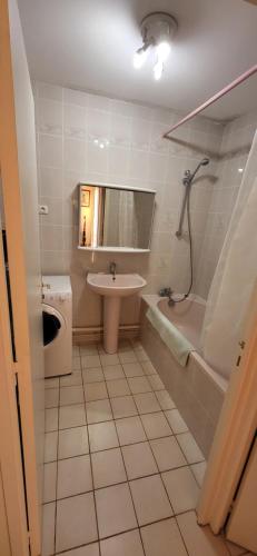 uma casa de banho com um lavatório, uma banheira e um WC. em Appartement les pieds dans l'eau em Saint-Cast-le-Guildo