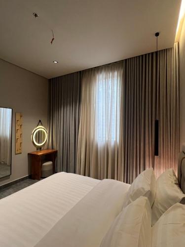 una camera da letto con un grande letto bianco e una finestra di Timber suites تمبر سويتس a Riyad