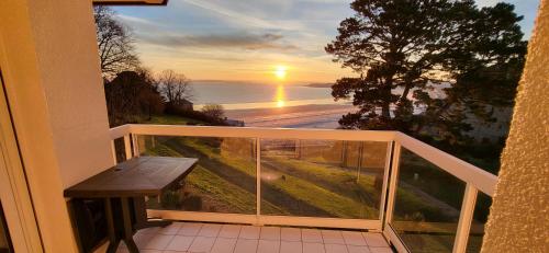 a balcony with a bench and a view of the ocean at Appartement les pieds dans l'eau in Saint-Cast-le-Guildo