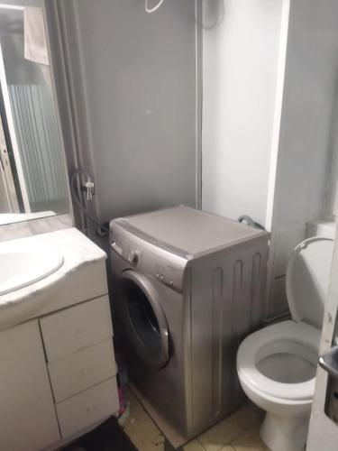 uma casa de banho com uma máquina de lavar roupa e um WC em Appartement de Charme au Cœur de Bourg-en-Bresse ! em Bourg-en-Bresse