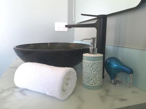 a bathroom with a black sink and a towel at Kahurangi Cottage Twizel in Twizel