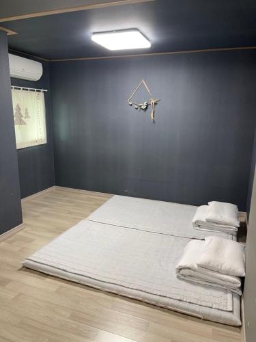 a large bed in a room with a black wall at Moonlight Hill Guesthouse in Mokpo
