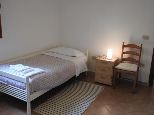 1 dormitorio pequeño con 1 cama y 1 silla en Geoglobe Apartment, en Pisa
