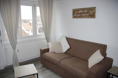 a living room with a couch and a window at L'Europ'appart : Gare, Center parcs, Parc St Croix in Sarrebourg