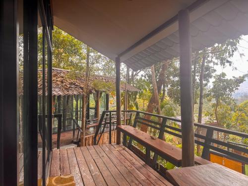 a porch of a house with a bench on it at Nakra Hill Mae on in Ban On Luai