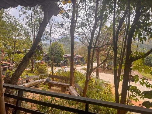 a wooden bench in a park with a fence at Nakra Hill Mae on in Ban On Luai