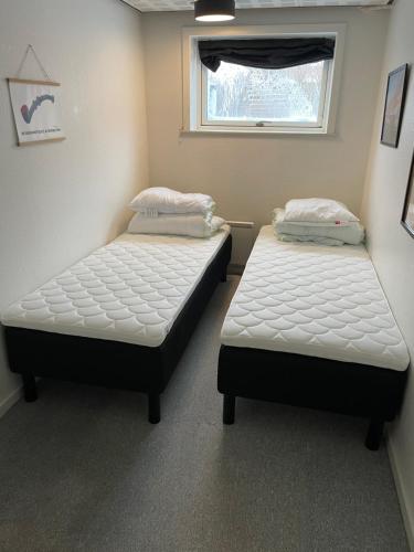 two twin beds in a room with a window at Happy Fisherman BnB in Aalborg