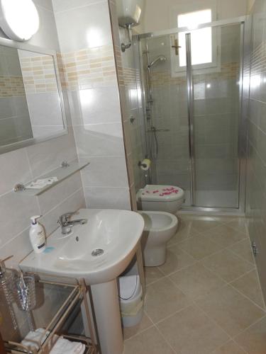 y baño con lavabo, aseo y ducha. en Geoglobe Apartment, en Pisa