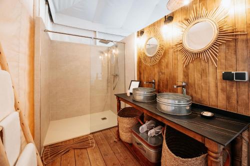 a bathroom with a sink and two mirrors on the wall at Inara Camp in El Karia