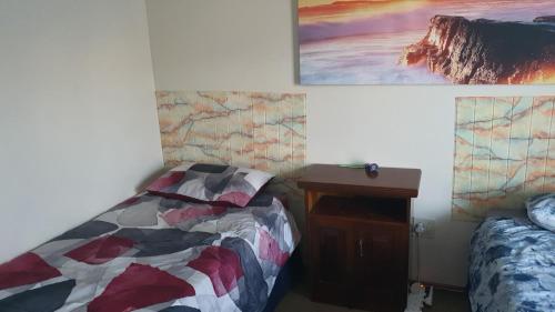 a bedroom with a bed and a desk and a picture at STW self catering in Langebaan