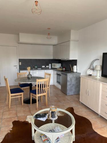 a kitchen with a table and chairs in a room at Appartement Mac Auliffe in Bastogne