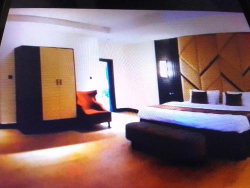 a bedroom with a bed and a couch in a room at Villa toscana luxe hotel and suites in Port Harcourt
