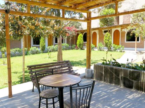 a patio with a table and chairs under a pergola at Hotel El Molle in Lunahuaná