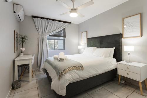 a bedroom with a bed and a desk and a window at Ocean Pearl at Chakas Cove - Beachfront Apartment in Ballito