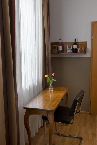a wooden table with a vase of flowers on it at hideauts hotels Der Rosengarten in Füssen