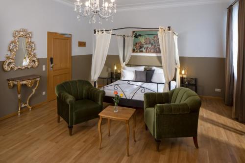 1 dormitorio con 1 cama, 2 sillas y mesa en hideauts hotels Der Rosengarten, en Füssen