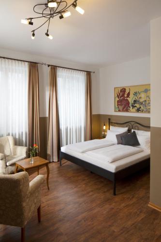 a bedroom with a large bed and a couch at hideauts hotels Der Rosengarten in Füssen