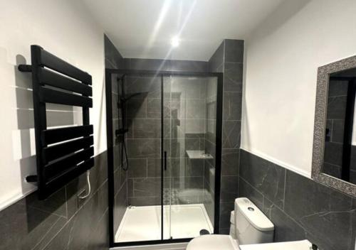 a bathroom with a glass shower and a toilet at Apartment by DH ApartHotels in Peterborough