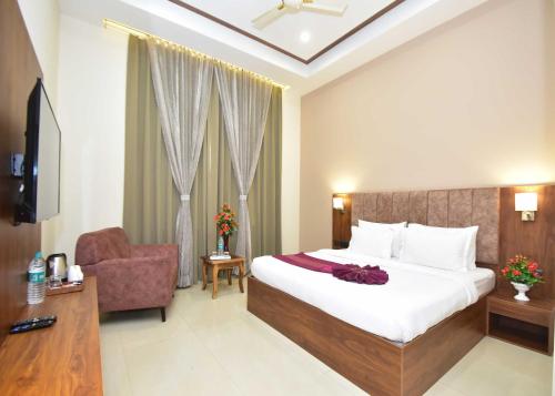 a hotel room with a bed and a chair at Hotel Shyamleela in Khātu