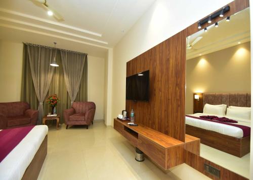 a hotel room with two beds and a television at Hotel Shyamleela in Khātu
