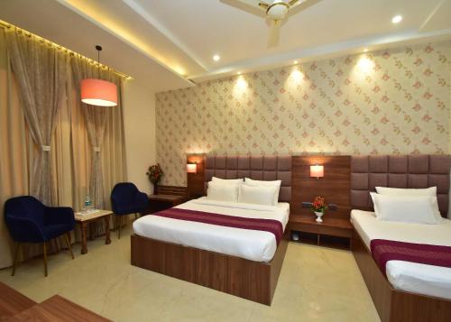 a hotel room with two beds and a table and chairs at Hotel Shyamleela in Khātu