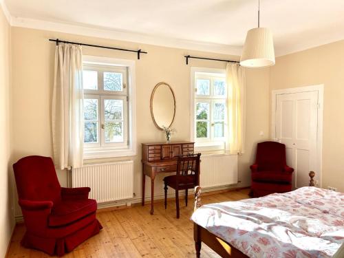 a bedroom with a bed and two chairs and a desk at Ferienwohnung Schloss Heldritt in Bad Rodach