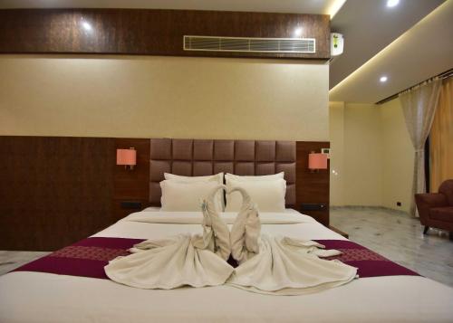 a bed with two wedding gowns on top of it at Hotel Shyamleela in Khātu