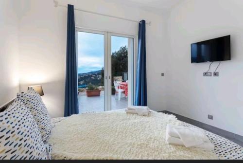 - une chambre avec un grand lit et une porte coulissante en verre dans l'établissement Gite Mare e Montagne Drap 06, à Drap