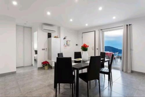 une salle à manger avec une table et des chaises noires dans l'établissement Gite Mare e Montagne Drap 06, à Drap