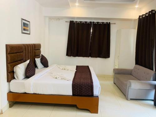 a bedroom with a bed and a couch in it at 1 Bhk Apartment 200 mtr from beach in Calangute